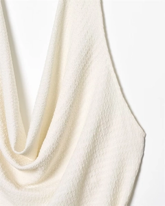 Close-up of white halter top featuring textured seersucker fabric and cowl neckline