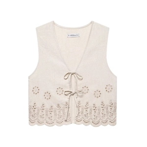 Close-up of eyelet floral embroidery and scalloped hem on beige linen blend vest