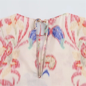 Detail of floral printed top featuring a back keyhole neck and elegant self-tie bow closure