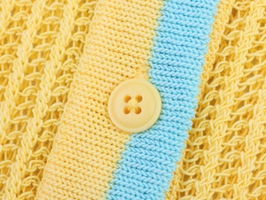 Détail du tissu en maille jaune vif avec rayures bleues et bouton assorti élégant
