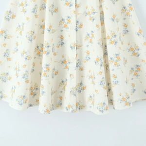 Detailed view of the yellow and blue floral print poplin skirt with white front buttons