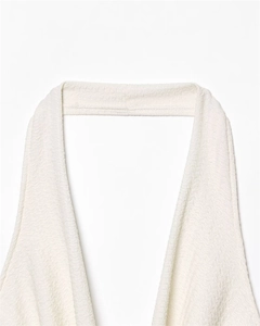 Detailed close-up of white halter top neck featuring elegant 3D wavy pleated texture fabric