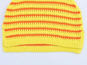 Dettaglio del tessuto a maglia a righe strutturate e dell'orlo a costine del gilet