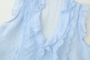 Detailed view of light blue sleeveless top with layered ruffles and sheer chiffon fabric