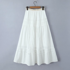 Detail of white bohemian maxi skirt showing delicate lace hollow patterns and tiered pleats