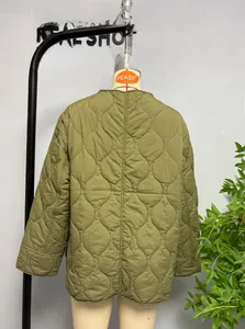 Detail of army green quilted jacket featuring onion stitch patterns and side slits