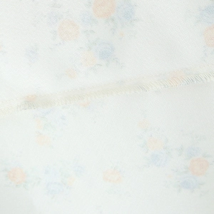 Detail of floral poplin dress showing precise overlock stitching and delicate flower print