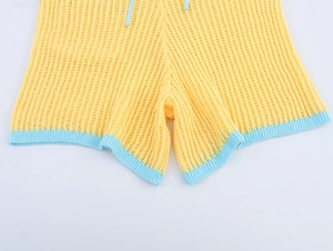 Détail du short en maille jaune avec bordure bleue contrastée et cordon de serrage