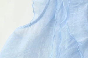 Detail of light blue tiered ruffles on sheer pleated chiffon fabric for women's top