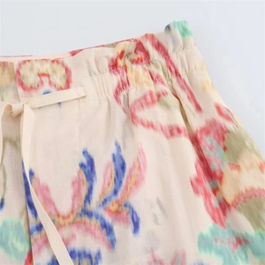 Detailed macro view of elastic drawstring waist with colorful tie-dye print on summer pants