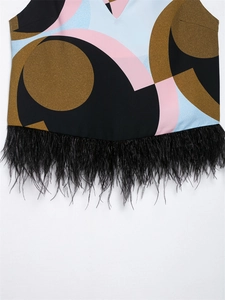Detail of geometric print top featuring elegant black feather fringe at the hemline