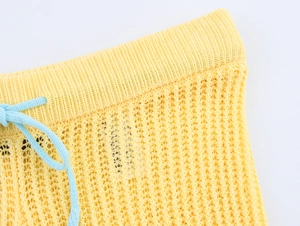 Détail de la taille du short en tricot jaune avec maille aérée et cordon de serrage bleu