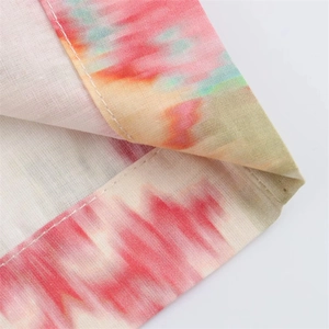 Macro shot of colorful tie-dye fabric texture and professional white flat-stitch seam detail