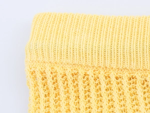 Détail macro de la maille côtelée jaune vif et de la texture au crochet sur cet ensemble