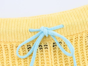 Détails du short en maille jaune avec cordon bleu clair et texture ajourée respirante