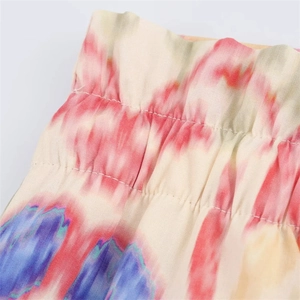 Detail of elastic ruffled paperbag waist on floral print trousers in pink and purple