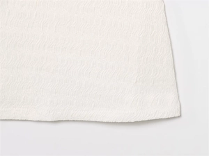 Détail de tissu blanc à texture ondulée avec motif plissé seersucker respirant et doux