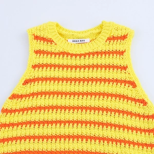 Top senza maniche in maglia a righe gialle e arancioni da donna su sfondo bianco neutro