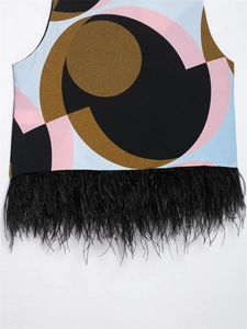 Detail of colorful geometric print top featuring elegant black feather fringe at the hem