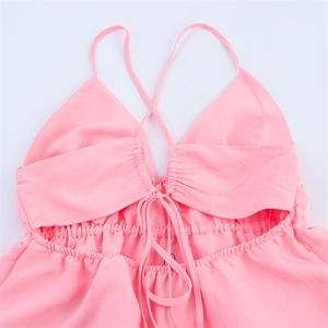 Détail de la robe midi rose clair avec fines bretelles et cordon de serrage froncé soigné