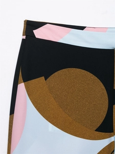 Macro shot of abstract geometric print fabric with black and pink patterns on wide-leg pants