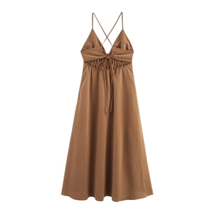 Détail d'une robe midi caramel montrant une découpe à la taille avec cordons de serrage
