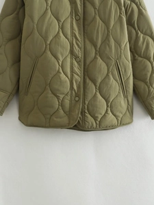 Detail of army green onion-quilted jacket with snap buttons and high-quality texture