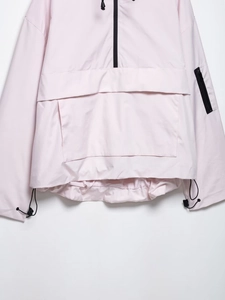 Detail der rosa Windjacke mit schwarzem Halbreißverschluss und verstellbarem Kordelzug