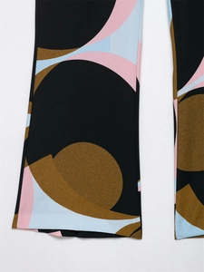 Detailed close-up of wide-leg trousers featuring vibrant abstract geometric pattern print