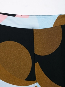 Macro detail of geometric print fabric with brown circles on black trousers