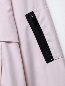 Nahaufnahme einer rosa Jacke mit professionellen Nähten und schwarzem Reißverschluss
