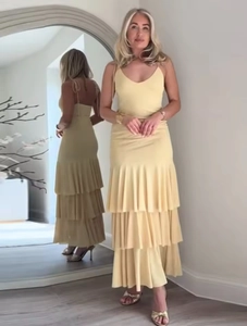Detail of pale yellow sleeveless V-neck maxi dress with tiered ruffle hem and strap design