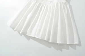 Détail rapproché de l'ourlet en tissu plissé blanc d'une robe de printemps à nœud