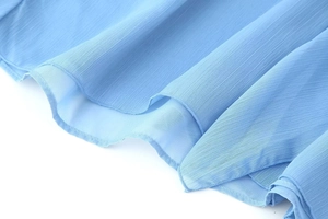 Detailed close-up of sky blue layered chiffon dress with pleated texture and fine hem stitching