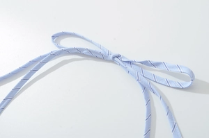 Detailed view of light blue and white diagonal striped fabric tie straps for dress