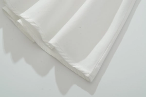 Gros plan du tissu en coton blanc montrant les détails de couture plate et d'ourlet