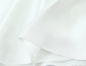 Detail of neat hem stitching on premium white satin fabric with smooth drape and texture
