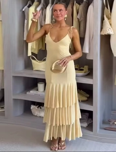 Detail of a pale yellow deep V-neck maxi dress with tiered ruffles and spaghetti straps
