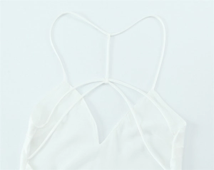 Detail of white satin dress featuring elegant crisscross thin back straps and V-neck line