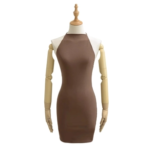 Détail d'une mini robe dos nu marron ajustée présentée sur un mannequin en bois