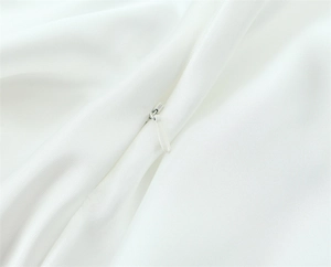 Macro view of a white invisible zipper on silky satin fabric with fine textile texture