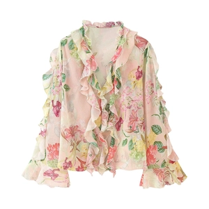 Close-up of feminine floral print chiffon blouse with delicate ruffled edges and cuffs
