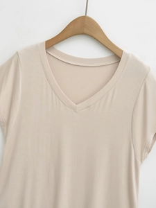 Detail of beige V-neck short sleeve top showing soft cotton fabric on wooden hanger
