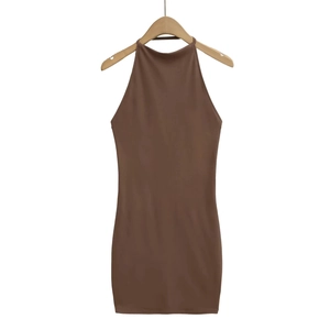 Détail d'une robe marron dos nu ajustée sur un cintre en bois avec texture de tissu lisse
