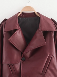 Detail view of burgundy faux leather jacket featuring wide lapels and smooth glossy texture