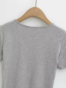 Close-up of neckline stitching and shoulder seam on light grey knitted t-shirt