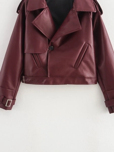 Macro detail of wine red faux leather jacket collar and waist belt with metal buckles