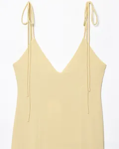 Détails des bretelles à nouer et du décolleté en V profond sur la robe jaune clair