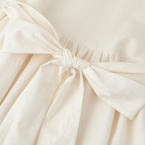 Elegant off-white knit dress featuring a waist bow tie and vertical ribbed texture details