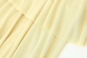 Close-up of pale yellow layered fabric showing fine knit texture and soft drape detail